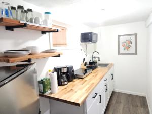 a kitchen with white cabinets and a wooden counter top at Lovely Private 2 Bedroom Suite near EWR/NYC in Newark