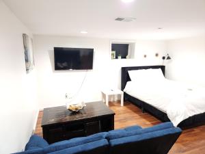 a living room with a bed and a blue couch at Lovely Private 2 Bedroom Suite near EWR/NYC in Newark