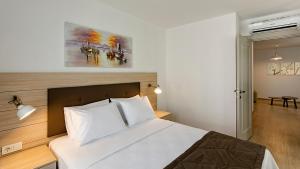 a bedroom with a bed and a painting on the wall at The Room Hotel & Apartments in Antalya