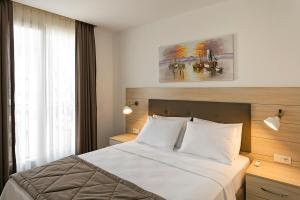 a bedroom with a bed and a painting on the wall at The Room Hotel & Apartments in Antalya
