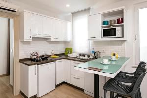 a kitchen with white cabinets and a table and chairs at The Room Hotel & Apartments in Antalya