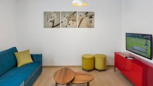 a living room with a couch and a table and a tv at The Room Hotel & Apartments in Antalya