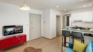 a kitchen and a living room with a red cabinet at The Room Hotel & Apartments in Antalya