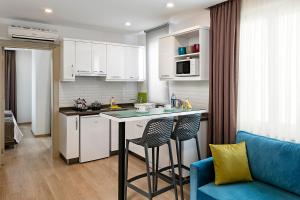 a kitchen with a table and a blue couch at The Room Hotel & Apartments in Antalya