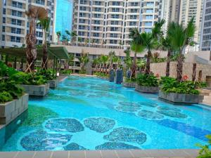 une grande piscine avec des palmiers et des bâtiments dans l'établissement Studio 17 Taman Anggrek Residence Best Cozy and Stay 50mbps Wifi, à Jakarta