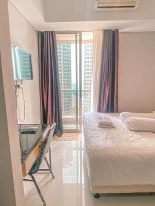 - une chambre avec un lit, un bureau et une fenêtre dans l'établissement Studio 17 Taman Anggrek Residence Best Cozy and Stay 50mbps Wifi, à Jakarta