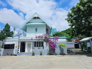 ein weißes Gebäude mit Blumen davor in der Unterkunft P.California Inter Hostel in Nang Rong