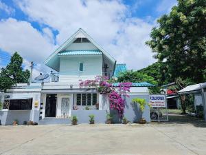P.California Inter Hostel في Nang Rong: مبنى ابيض بالورود امامه