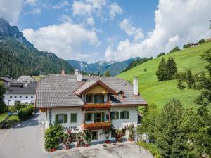 a house with flowers in front of a mountain at Gasthof Albergo Dolomiten in Braies