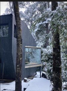 un bâtiment avec une fenêtre dans la neige dans l'établissement Casa Gallareta , luxury con costa del lago ., à Villa La Angostura