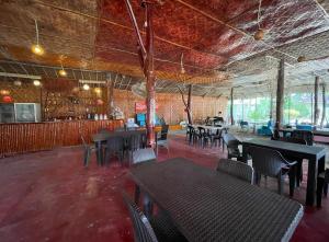 a restaurant with tables and chairs in a room at Beach Placid Resort powered by Cocotel in Ocoy