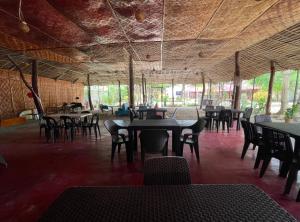 a dining room with tables and chairs in a building at Beach Placid Resort powered by Cocotel in Ocoy