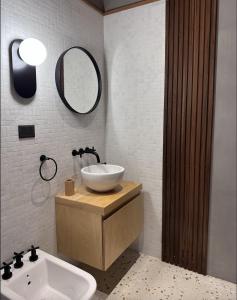 La salle de bains est pourvue d'un lavabo et d'un miroir. dans l'établissement Casa Gallareta , luxury con costa del lago ., à Villa La Angostura