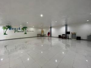 a large room with a white tile floor and a large wall at Beach Placid Resort powered by Cocotel in Ocoy