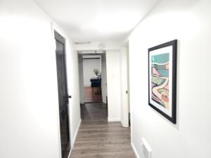a hallway with white walls and a framed painting on a wall at Lovely Private 2 Bedroom Suite near EWR/NYC in Newark +1 photo