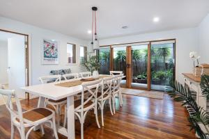 a dining room with a white table and chairs at Preston Alfresco Poolside Retreat Rye in Rye