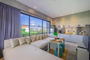 ein Wohnzimmer mit einem weißen Sofa und einem großen Fenster in der Unterkunft BLANCA8 - 21 - Bali Invest Club in Canggu