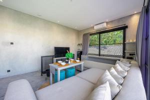 ein Wohnzimmer mit einem Sofa und einem Tisch in der Unterkunft BLANCA8 - 21 - Bali Invest Club in Canggu