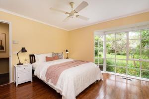 1 dormitorio con 1 cama y ventilador de techo en Inglewood Gardens, en Rosebud