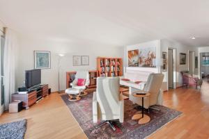 a living room with a table and chairs at Alpes - Large apartment with amazing view on Lake Geneva in Montreux