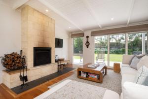 a living room with a white couch and a fireplace at Blairgowrie Beauty By The Beach in Blairgowrie