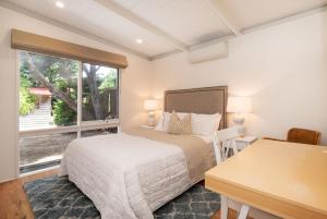 a bedroom with a bed and a desk and a window at Blairgowrie Beauty By The Beach in Blairgowrie