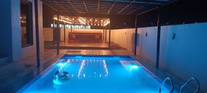 a swimming pool with blue lights in a room at استراحة المرجان 