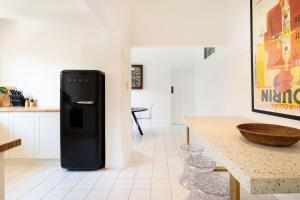 a black refrigerator in a kitchen with a table at Castelnau in Melbourne