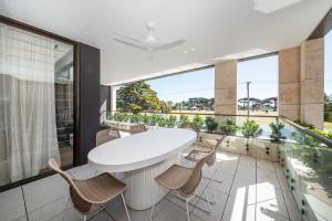 a dining room with a white table and chairs on a balcony at Oceano Residence Mornington in Mornington