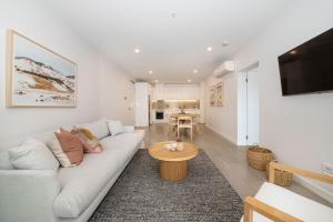 a living room with a white couch and a table at Apartment Living on the Beach in Rosebud