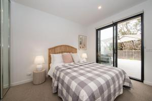 a bedroom with a bed and a large window at Apartment Living on the Beach in Rosebud
