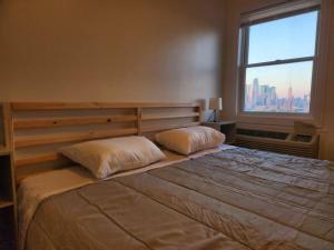um quarto com uma cama grande e uma janela grande em Luxurious 2 bed ! mins to NYC! em Union City