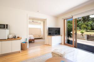 a living room with a television and a sliding glass door at The Royal Apartment in Mornington in Mornington