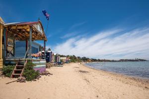 a beach with a building on the shore of the water at The Royal Apartment in Mornington in Mornington