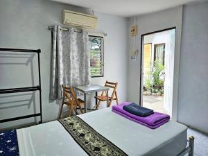 Habitación con 2 camas, mesa y ventana en P.California Inter Hostel en Nang Rong