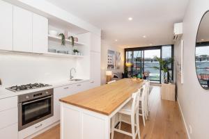 uma cozinha com armários brancos e um balcão de madeira em Bayside living at The Hampton em Melbourne