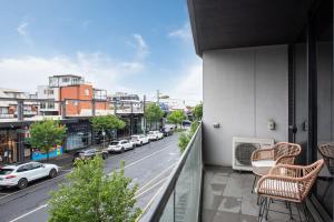 einen Balkon mit Stühlen und Blick auf eine Stadtstraße in der Unterkunft Bayside living at The Hampton in Melbourne