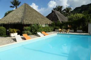 ein Pool mit Stühlen und ein Resort in der Unterkunft Hotel Le Mahana in Parea