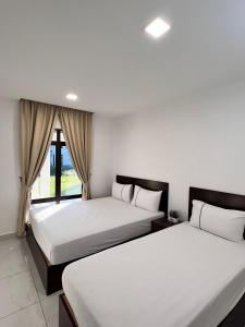 two beds in a room with a window at TheDot 903 @ A’Famosa Villa NEW VILLA in Kampong Alor Gajah