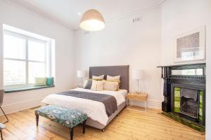 a bedroom with a large bed and a fireplace at Stylish Contemporary Retreat St Kilda in Melbourne