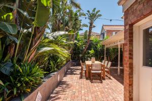 a patio with a table and chairs and plants at Stylish Contemporary Retreat St Kilda in Melbourne