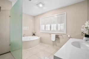 une salle de bain blanche avec une baignoire et un lavabo dans l'établissement Darling Villa Biani in Sorrento with Spa, à Sorrento 26 autres photos