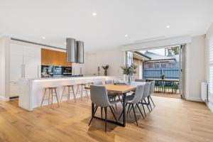 uma cozinha e sala de jantar com mesa e cadeiras em Luxe Parkside Hampton Home em Melbourne