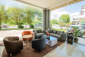 un soggiorno con divani, sedie e tavolo di Hotel Meliden a Sandakan