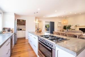 拉伊的住宿－Driftwood Family Oasis in Rye，厨房配有白色橱柜和炉灶烤箱。