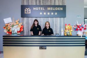 two girls standing behind a counter at a hotel meliden at Hotel Meliden in Sandakan