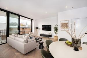 - un salon avec un canapé et une table dans l'établissement Sport Precinct Luxury Style over four levels, à Melbourne