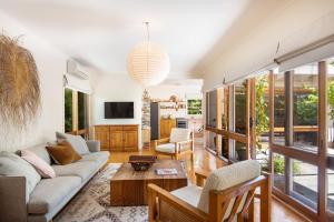 a living room with a couch and a table at Bessie at Merricks Beach in Coles Beach