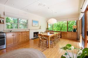 a kitchen and dining room with a table and chairs at Bessie at Merricks Beach in Coles Beach