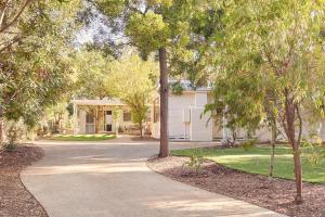 a driveway leading to a house with trees at Bessie at Merricks Beach in Coles Beach